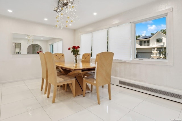 tiled dining room with a baseboard radiator and a notable chandelier