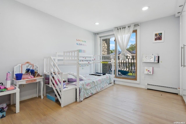 bedroom featuring light wood-type flooring, access to outside, and a baseboard heating unit