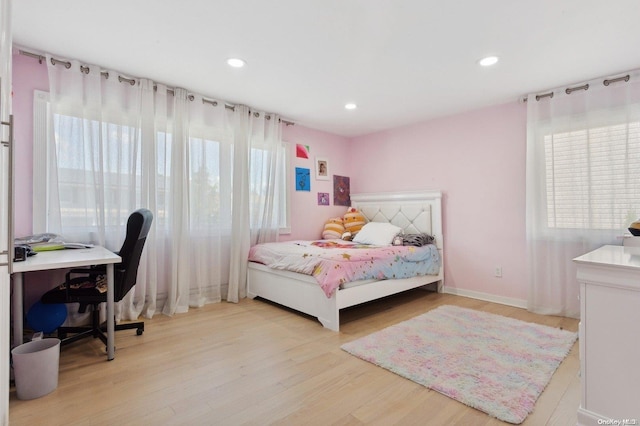 bedroom with multiple windows and light hardwood / wood-style floors