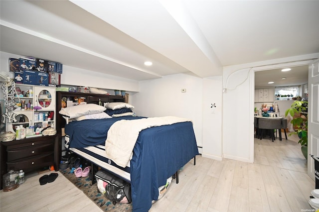 bedroom featuring light wood-type flooring and a baseboard heating unit