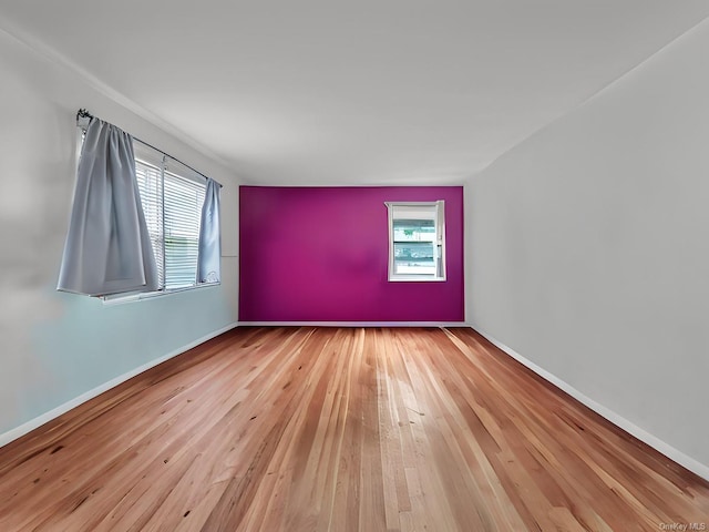 unfurnished room featuring wood-type flooring and baseboards