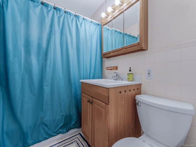 bathroom featuring vanity, tile walls, toilet, and a shower with shower curtain