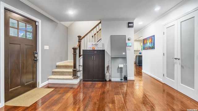 entrance foyer featuring ornamental molding and dark hardwood / wood-style flooring