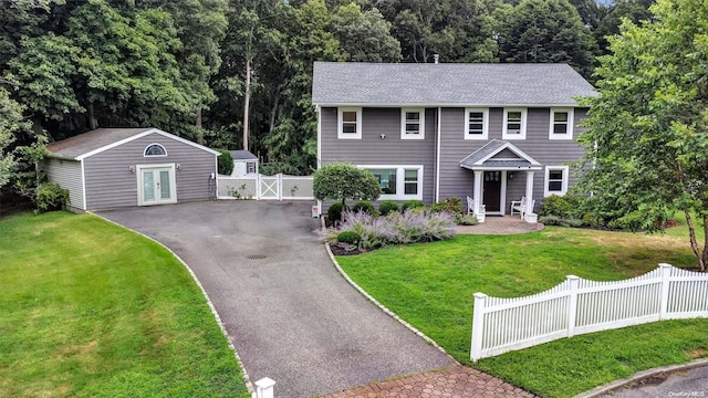 colonial house featuring an outdoor structure and a front lawn