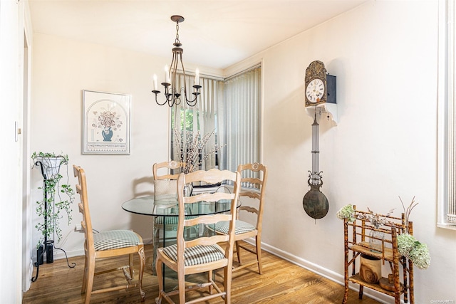 dining area featuring wood-type flooring and an inviting chandelier