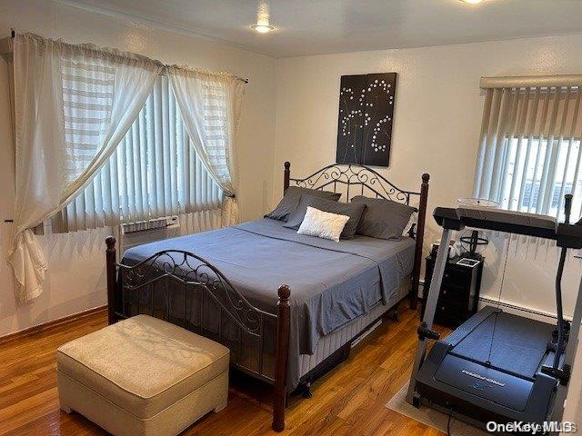 bedroom featuring hardwood / wood-style flooring and a baseboard radiator