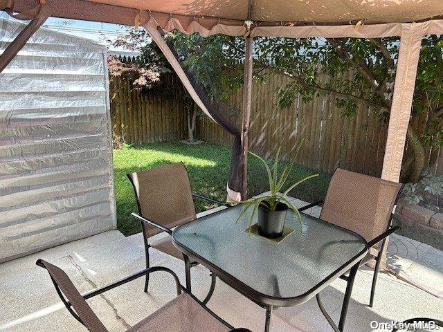 920 Broadway Unit 15, Woodmere, NY 11598 - fenced backyard featuring outdoor dining area and a patio