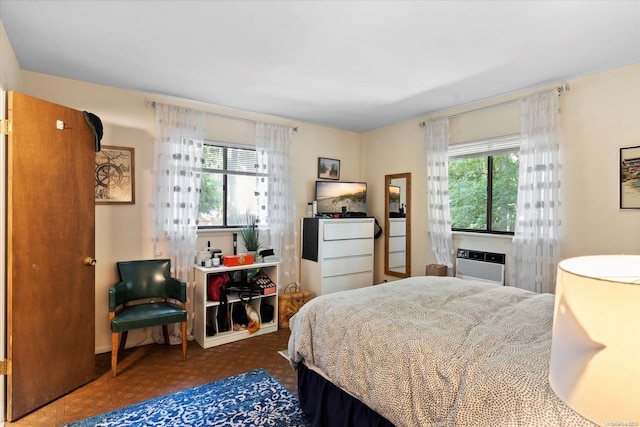 bedroom with a wall unit AC, multiple windows, and dark parquet floors