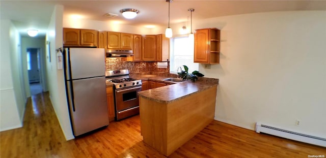 kitchen featuring kitchen peninsula, stainless steel appliances, a baseboard heating unit, decorative light fixtures, and light hardwood / wood-style flooring