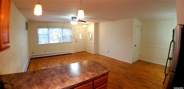 foyer entrance with ceiling fan, light hardwood / wood-style floors, and a baseboard heating unit