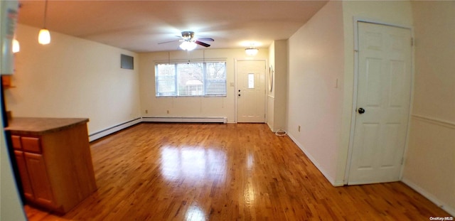 unfurnished living room featuring hardwood / wood-style flooring, ceiling fan, and a baseboard radiator