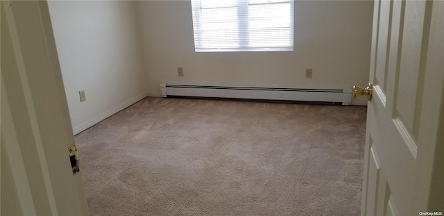 spare room with light colored carpet and a baseboard radiator