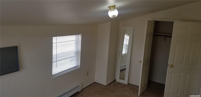 unfurnished bedroom with carpet flooring, a baseboard radiator, vaulted ceiling, and a closet