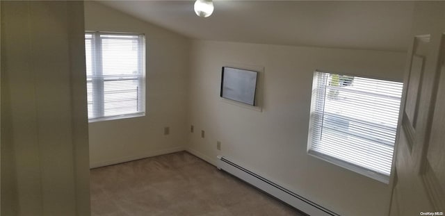 spare room featuring carpet flooring, a healthy amount of sunlight, vaulted ceiling, and a baseboard radiator