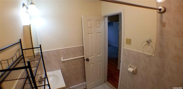 bathroom with baseboard heating, tile walls, and hardwood / wood-style flooring