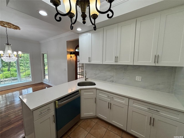 kitchen with hardwood / wood-style floors, dishwasher, white cabinets, sink, and a chandelier