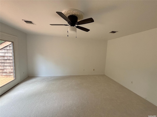 spare room featuring light carpet and ceiling fan