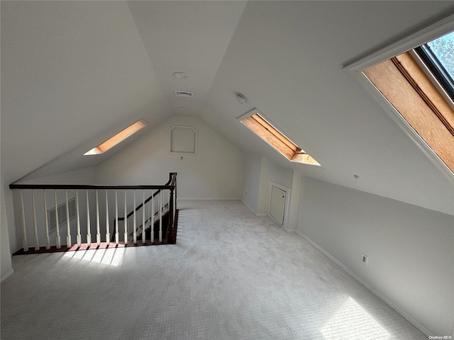 bonus room featuring light carpet and lofted ceiling with skylight