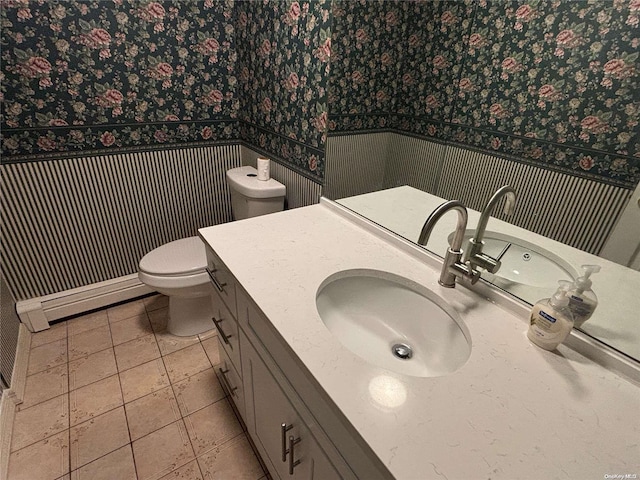 bathroom featuring tile patterned floors, baseboard heating, vanity, and toilet