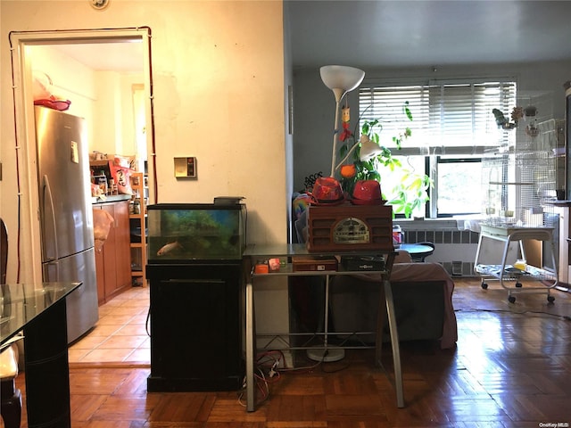 kitchen featuring stainless steel refrigerator, radiator heating unit, and parquet floors