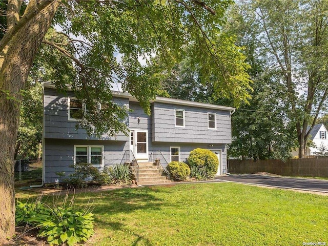 bi-level home with a front yard and a garage