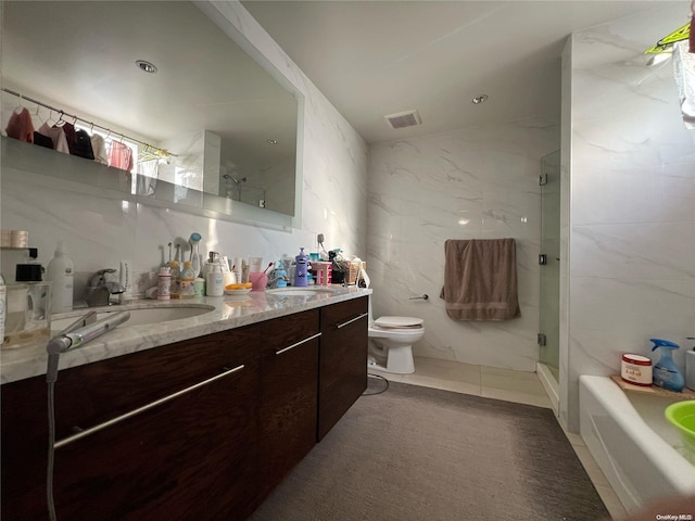 bathroom featuring vanity, toilet, an enclosed shower, and tile walls