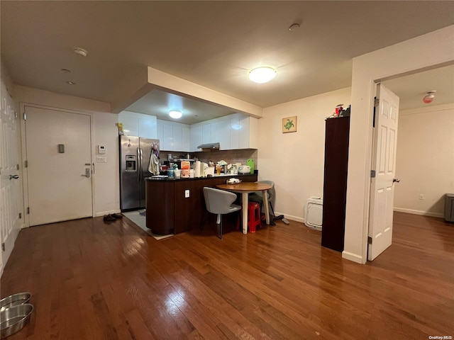 kitchen featuring white cabinetry, stainless steel fridge with ice dispenser, dark wood-type flooring, and a kitchen breakfast bar