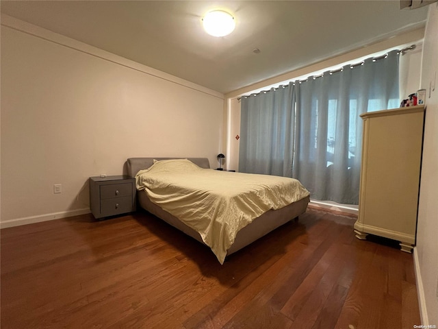 bedroom with dark hardwood / wood-style floors