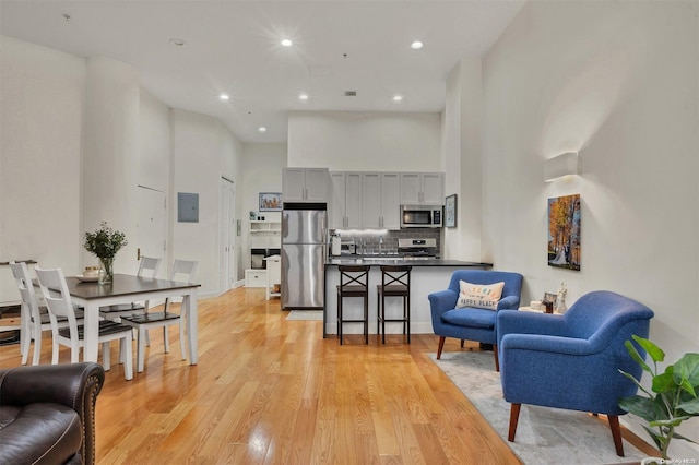 living room with light hardwood / wood-style flooring and a towering ceiling