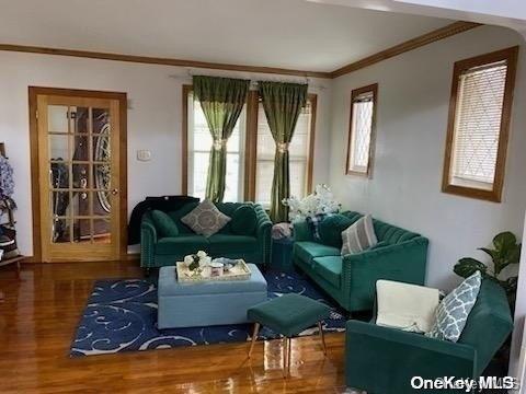 sitting room with crown molding and hardwood / wood-style floors