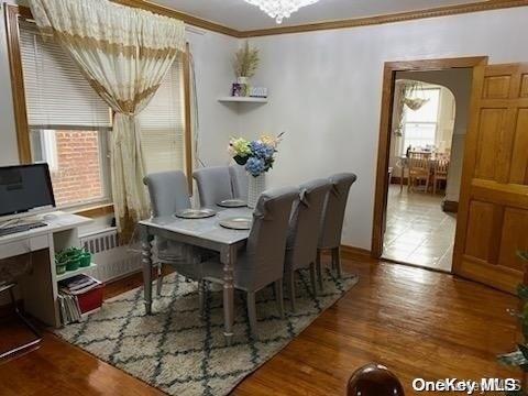 dining area featuring a notable chandelier, dark hardwood / wood-style floors, and crown molding