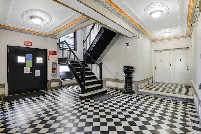 entryway featuring a tray ceiling and ornamental molding