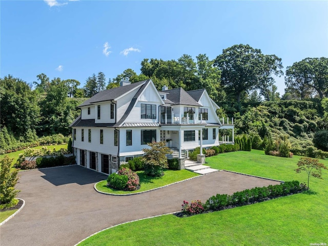 view of front of house featuring a front yard, a garage, and covered porch