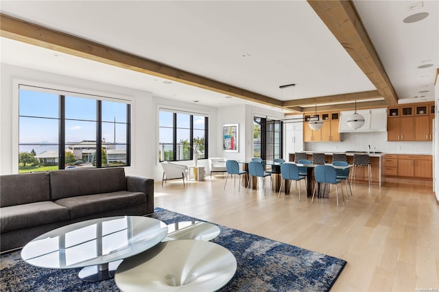 living room with beam ceiling and light hardwood / wood-style flooring