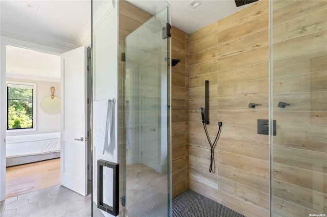 bathroom with tile patterned floors, a shower with shower door, and ornamental molding