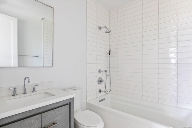 full bathroom featuring vanity, tiled shower / bath, and toilet