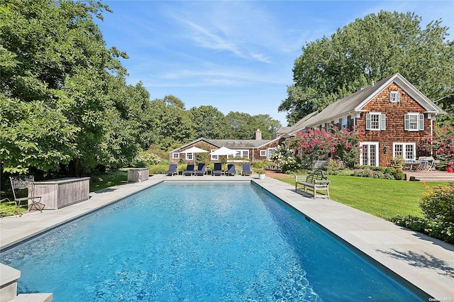 view of pool with a lawn