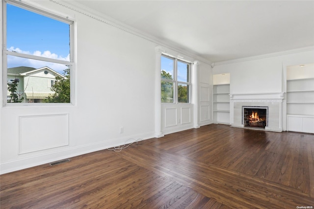 unfurnished living room featuring dark hardwood / wood-style flooring, built in features, and ornamental molding