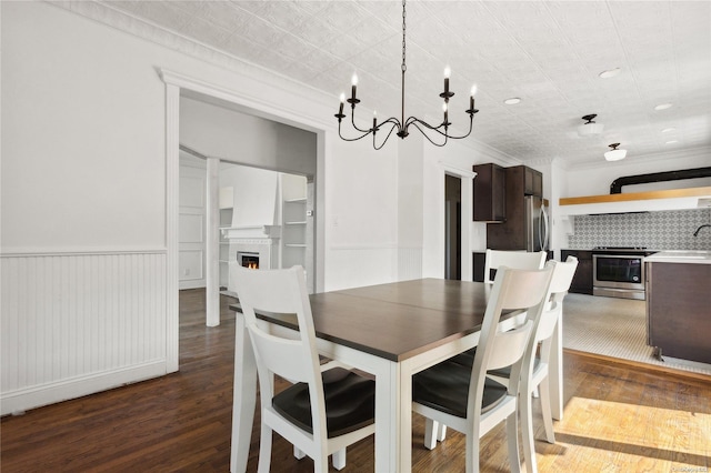 dining area featuring dark hardwood / wood-style flooring, a notable chandelier, and sink