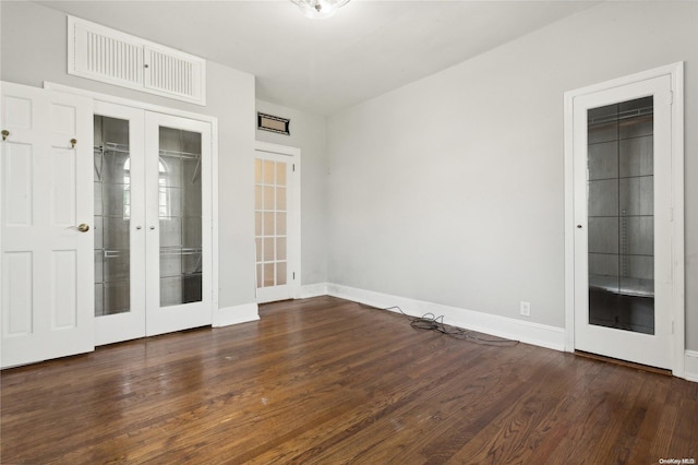 empty room with dark hardwood / wood-style flooring and french doors