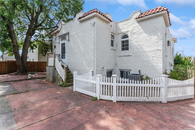 rear view of property with a patio area and central AC unit