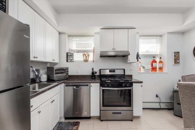 kitchen featuring sink, stainless steel appliances, a baseboard radiator, light tile patterned floors, and white cabinets