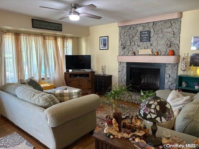 living room with ceiling fan, dark wood-type flooring, and a healthy amount of sunlight