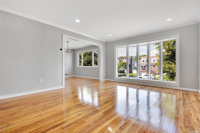 unfurnished room featuring light hardwood / wood-style flooring, an inviting chandelier, and ornamental molding