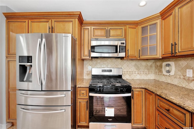 kitchen with decorative backsplash, light stone counters, and appliances with stainless steel finishes