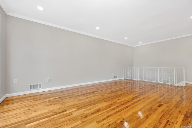 empty room featuring light hardwood / wood-style flooring and ornamental molding