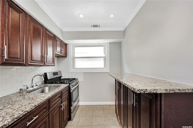 kitchen featuring gas stove, sink, tasteful backsplash, light tile patterned floors, and ornamental molding