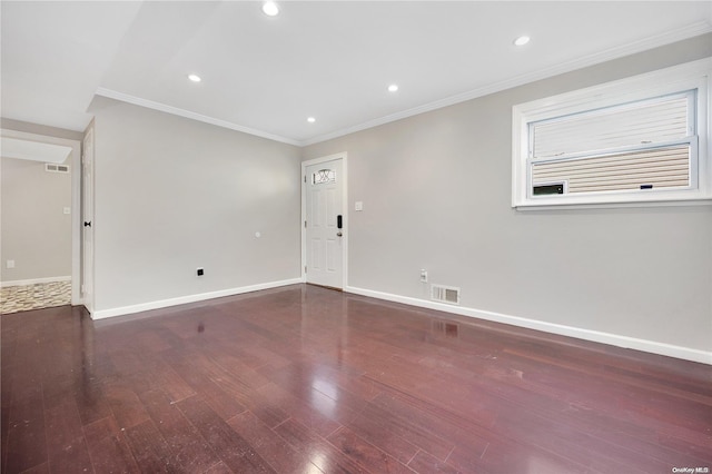 spare room featuring dark hardwood / wood-style flooring and crown molding