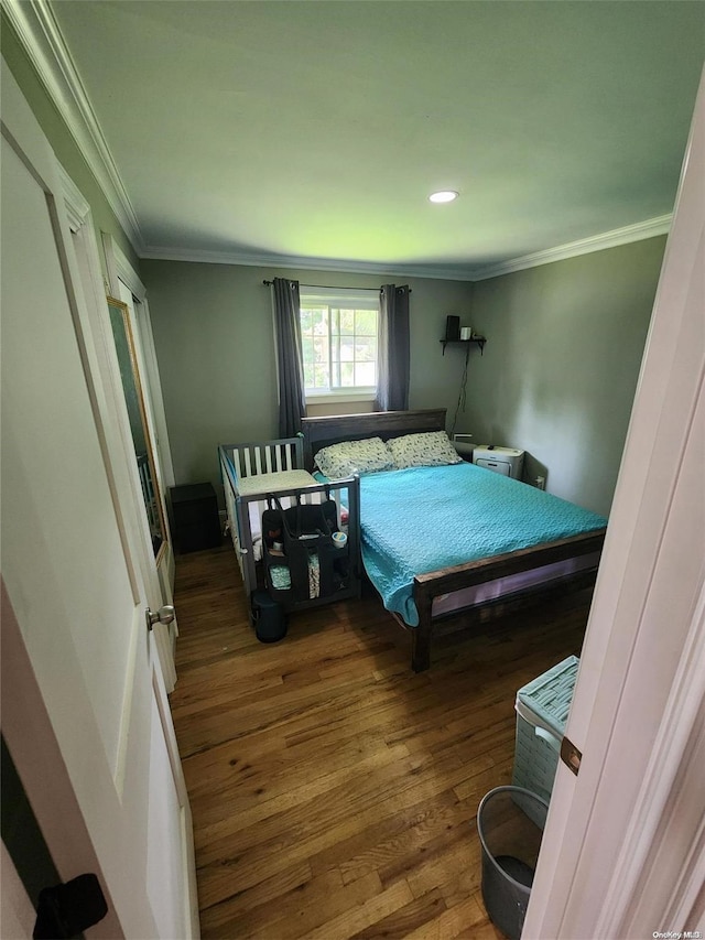 bedroom with hardwood / wood-style flooring and ornamental molding