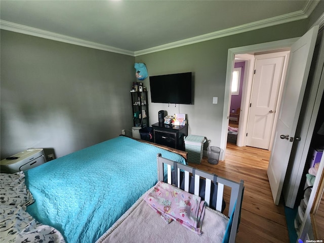 bedroom with wood-type flooring and crown molding